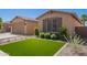 Well-maintained front yard with artificial turf and tidy desert landscaping at 233 W Sweet Shrub Ave, San Tan Valley, AZ 85140
