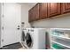 Laundry room featuring a washer and dryer, with overhead cabinets for extra storage at 233 W Sweet Shrub Ave, San Tan Valley, AZ 85140