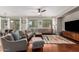 Bright living room with a ceiling fan, gray sofas, a rug and sliding glass doors leading to outdoor area at 233 W Sweet Shrub Ave, San Tan Valley, AZ 85140