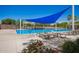 Relaxing community pool with lounge chairs, clear blue water, shade sails and mature desert landscaping at 233 W Sweet Shrub Ave, San Tan Valley, AZ 85140