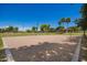 Outdoor sand volleyball court with palm trees, grass and basketball courts in the background on a bright sunny day at 233 W Sweet Shrub Ave, San Tan Valley, AZ 85140