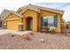 Single-story home with a desert landscape, adorned with colorful flowers and a charming sun detail above the entryway at 23814 W Chambers W St, Buckeye, AZ 85326