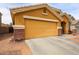 Two-car garage with brick-trimmed facade and driveway at 23814 W Chambers W St, Buckeye, AZ 85326
