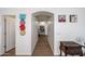 Bright hallway featuring wood floors, decorative wall art, and an arched entryway at 23814 W Chambers W St, Buckeye, AZ 85326