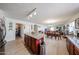 Open concept kitchen flowing into dining and living areas with an island and stainless steel trash receptacle at 23814 W Chambers W St, Buckeye, AZ 85326