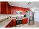 Modern kitchen with stainless steel appliances, granite countertops, and warm wood cabinetry at 23814 W Chambers W St, Buckeye, AZ 85326