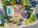 A tile roof tops a home with a sparkling pool, driveway and mature landscaping at 2438 N Forest Cir, Mesa, AZ 85203