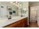Bathroom featuring a double vanity with wood cabinets, white countertops, and a framed mirror at 2438 N Forest Cir, Mesa, AZ 85203