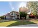 Two-story home with a tile roof and balcony, surrounded by a green lawn and mature trees at 2438 N Forest Cir, Mesa, AZ 85203