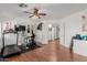 Spacious home gym featuring multiple workout machines, wood flooring, and a ceiling fan at 2438 N Forest Cir, Mesa, AZ 85203