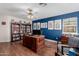 The home office provides wood floors, a bookcase, and ample space for a large desk at 2438 N Forest Cir, Mesa, AZ 85203
