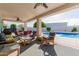 Covered outdoor patio featuring cushioned seating and a dining table, next to the backyard pool at 2438 N Forest Cir, Mesa, AZ 85203