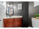 Stylish powder room with dark walls, wood vanity, and modern fixtures at 2438 N Forest Cir, Mesa, AZ 85203