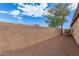 View of the fenced backyard with a mature tree at 25212 W Maldonado Dr, Buckeye, AZ 85326