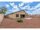 Backyard with gravel, plant beds and a rear view of the home with covered patio at 25212 W Maldonado Dr, Buckeye, AZ 85326