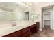 This bathroom features double sinks with granite countertops, a large mirror, and tile flooring at 25212 W Maldonado Dr, Buckeye, AZ 85326