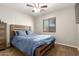 Comfortable carpeted bedroom with a ceiling fan, window and a wooden bed frame at 25212 W Maldonado Dr, Buckeye, AZ 85326