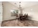 Formal dining room featuring a grand wooden table set, decorative chandelier, and abundant natural light from a large window at 25212 W Maldonado Dr, Buckeye, AZ 85326