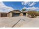 Tan single story home featuring a spacious driveway, two-car garage, and xeriscaped yard, under a partly cloudy sky at 25212 W Maldonado Dr, Buckeye, AZ 85326