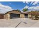 Tan single story home featuring a spacious driveway, two-car garage, and xeriscaped yard, under a partly cloudy sky at 25212 W Maldonado Dr, Buckeye, AZ 85326