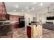 Modern kitchen boasts dark wood cabinets, granite countertops, stainless steel appliances, and an eat-in island at 25212 W Maldonado Dr, Buckeye, AZ 85326