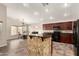 Open-concept kitchen featuring dark cabinetry, a raised bartop, pendant lighting and seamlessly flowing into the dining area at 25212 W Maldonado Dr, Buckeye, AZ 85326