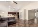 Open-concept living space features high ceilings, a comfortable sectional, and tile floors, seamlessly flowing into the kitchen and dining areas at 25212 W Maldonado Dr, Buckeye, AZ 85326