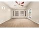 The main bedroom boasts neutral carpet, a ceiling fan, multiple windows, and a sliding glass door at 25212 W Maldonado Dr, Buckeye, AZ 85326