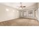 Spacious main bedroom with neutral carpeting, ceiling fan, and an abundance of natural light at 25212 W Maldonado Dr, Buckeye, AZ 85326