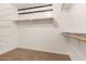 Spacious walk-in closet with wood rod and shelf, wire shelving, and black hooks for optimal organization at 25212 W Maldonado Dr, Buckeye, AZ 85326
