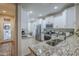 Modern kitchen with white cabinets, stainless steel appliances, and granite countertops for a sleek, functional space at 26071 W Sequoia Dr, Buckeye, AZ 85396