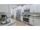 Modern kitchen with white cabinets, stainless steel appliances, and granite countertops for a sleek, functional space at 26071 W Sequoia Dr, Buckeye, AZ 85396