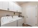 Well-equipped laundry room with white appliances and ample cabinet storage space at 26071 W Sequoia Dr, Buckeye, AZ 85396