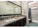 Bathroom featuring a double sink vanity, large mirror, and shower-tub combination with decorative shower curtain at 2643 E Menlo St, Mesa, AZ 85213