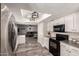 Bright kitchen boasts stainless steel appliances, white cabinets, and an open floorplan at 2643 E Menlo St, Mesa, AZ 85213