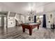 Open-concept living room with new floors, staircase, and pool table at 2643 E Menlo St, Mesa, AZ 85213