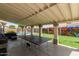Entertaining backyard with ping pong table on covered patio, beautiful wall art, and an inviting outdoor space at 2643 E Menlo St, Mesa, AZ 85213