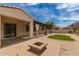 The backyard features gravel, a patch of grass, and a quaint fire pit for entertaining at 26860 N 102Nd Ln, Peoria, AZ 85383