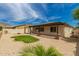 A sunny backyard with gravel, a pergola, and a green patch of manicured grass at 26860 N 102Nd Ln, Peoria, AZ 85383