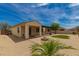 A sun-filled backyard with gravel, a fire pit, and a green patch of manicured grass at 26860 N 102Nd Ln, Peoria, AZ 85383