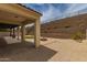 The backyard features gravel, a small patch of grass, and a tiered retaining wall at 26860 N 102Nd Ln, Peoria, AZ 85383