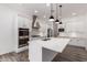 A bright kitchen is showcased with white cabinets, stainless steel appliances, a center island, and pendant lighting at 26860 N 102Nd Ln, Peoria, AZ 85383