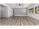 Spacious living room with wood-look floors, neutral gray walls, and large windows providing ample light at 26860 N 102Nd Ln, Peoria, AZ 85383