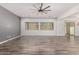 Bright living room featuring wood-look floors, neutral gray walls, and sliding glass doors to the backyard at 26860 N 102Nd Ln, Peoria, AZ 85383