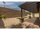 Relaxing patio with pergola, brick columns, and a view of the terraced backyard at 26860 N 102Nd Ln, Peoria, AZ 85383