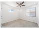Clean, carpeted bedroom with a ceiling fan and two bright windows at 29339 N 67Th Ave, Peoria, AZ 85383