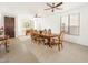 Spacious dining room featuring a classic wood table set under a ceiling fan and natural light from large windows at 29339 N 67Th Ave, Peoria, AZ 85383