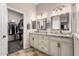 Luxurious bathroom featuring dual sinks, granite countertops, and a walk-in closet with ample storage space at 3256 E Maplewood St, Gilbert, AZ 85297