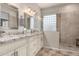 Elegant bathroom with dual sinks, granite countertops, a glass-enclosed shower, and stylish tile flooring at 3256 E Maplewood St, Gilbert, AZ 85297