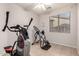 Bright exercise room with tile flooring, large window, ceiling fan, and home gym equipment at 3256 E Maplewood St, Gilbert, AZ 85297